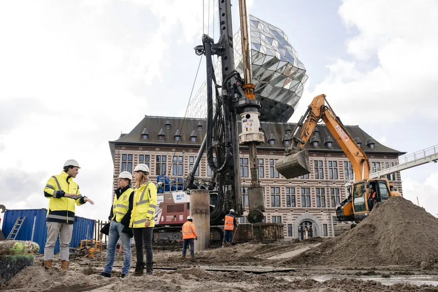 Boorstelling en graafmachine aan het werk bij een historisch gebouw